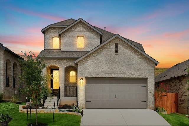 french provincial home with a garage and a lawn