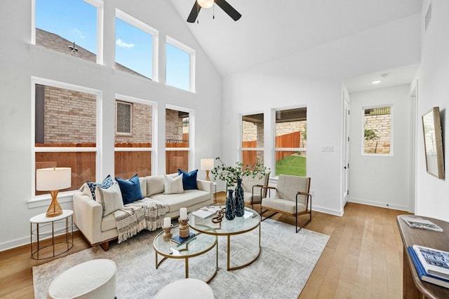 living room featuring high vaulted ceiling, plenty of natural light, light hardwood / wood-style flooring, and ceiling fan