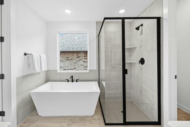 bathroom with plus walk in shower, tile walls, and tile patterned floors