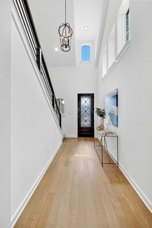 foyer featuring plenty of natural light, a notable chandelier, and light hardwood / wood-style floors