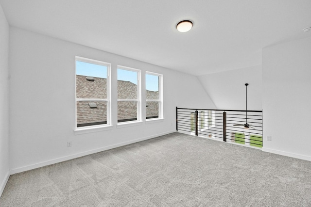 carpeted empty room with lofted ceiling