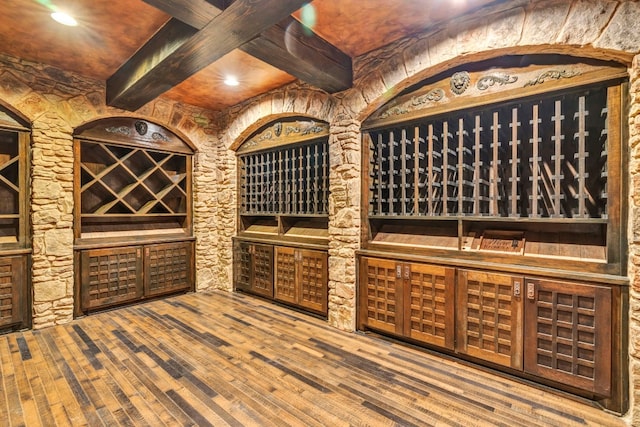 wine area with beam ceiling and hardwood / wood-style flooring