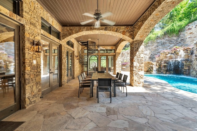 view of patio / terrace featuring french doors, pool water feature, and ceiling fan