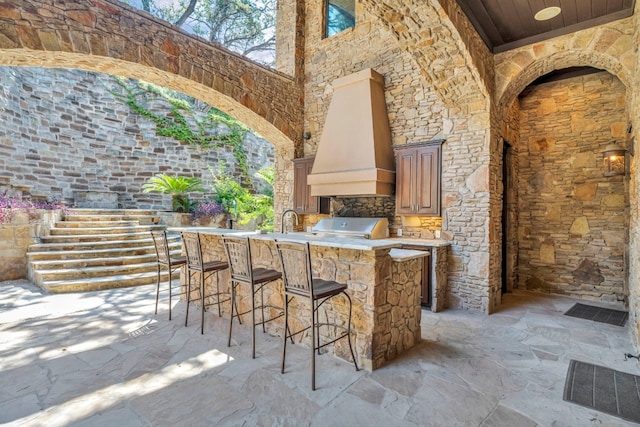 view of patio / terrace featuring area for grilling, an outdoor wet bar, and exterior kitchen