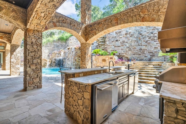 view of patio featuring exterior kitchen and sink