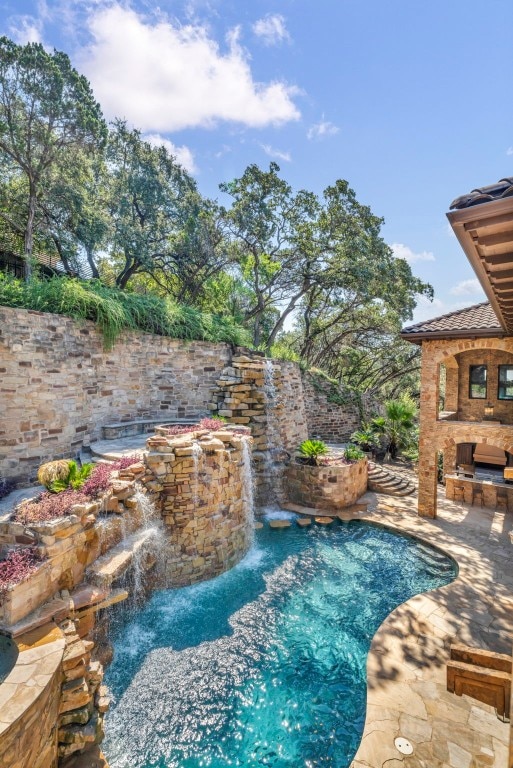 view of pool with pool water feature and a patio