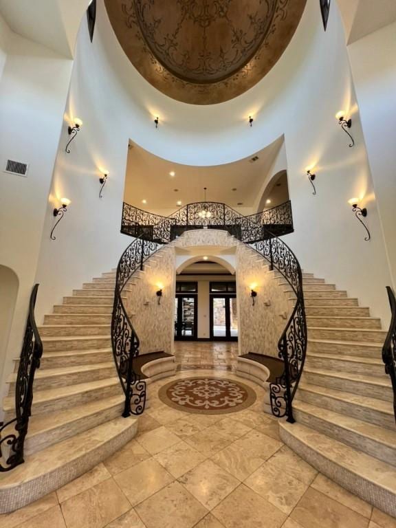 staircase with a high ceiling and french doors