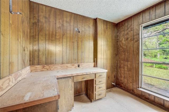 unfurnished office with a textured ceiling and wooden walls