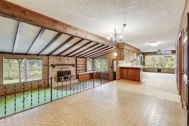 interior space featuring tile patterned floors, a fireplace, lofted ceiling with beams, wood walls, and a textured ceiling