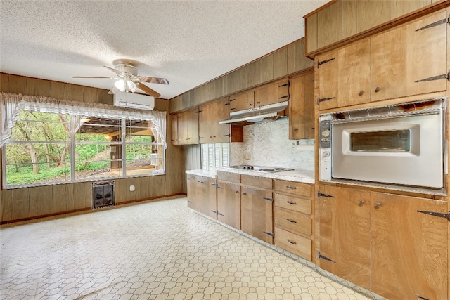 kitchen with light tile patterned floors, backsplash, beverage cooler, ceiling fan, and a wall mounted AC