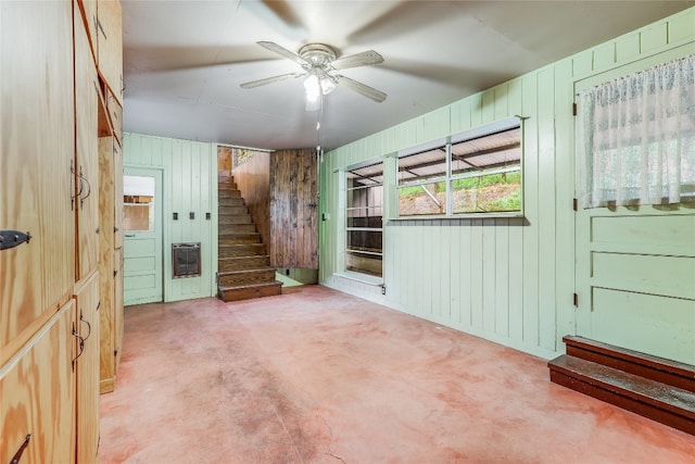 interior space with wooden walls and ceiling fan