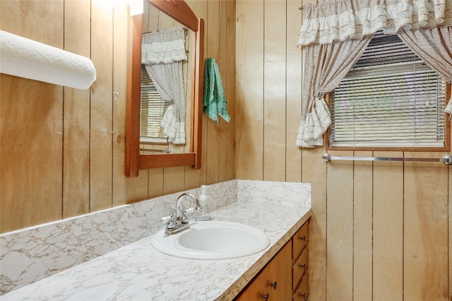 bathroom with vanity and wooden walls