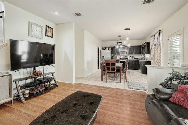 living room with a chandelier and light wood-type flooring