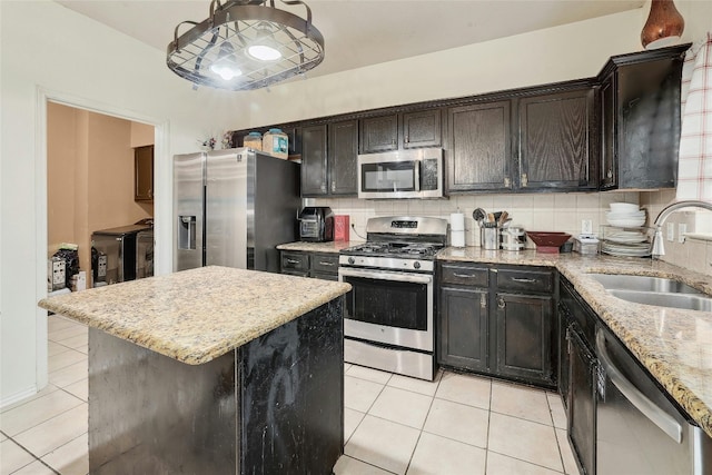 kitchen with backsplash, sink, light tile floors, and stainless steel appliances