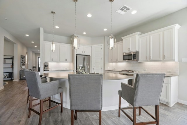 kitchen with white cabinetry, a kitchen bar, and appliances with stainless steel finishes