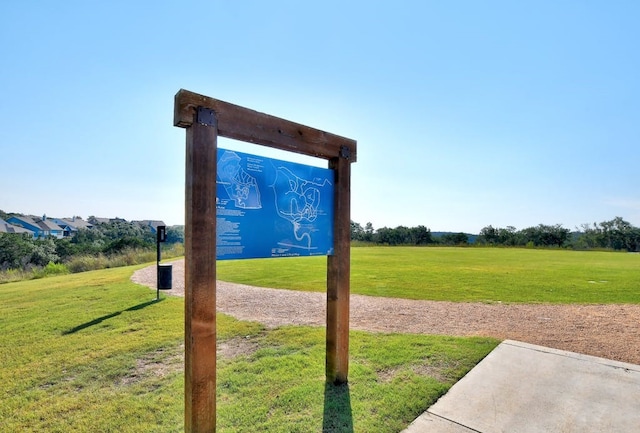 community sign featuring a yard