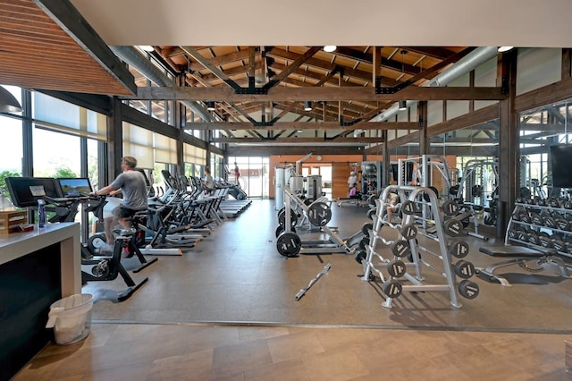 exercise room with tile floors and high vaulted ceiling