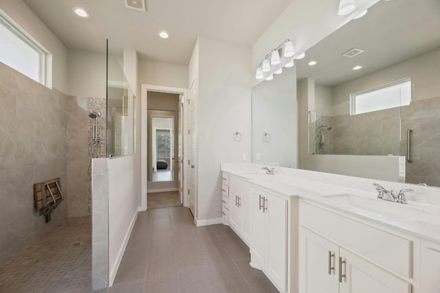 bathroom featuring double sink, walk in shower, tile floors, and oversized vanity