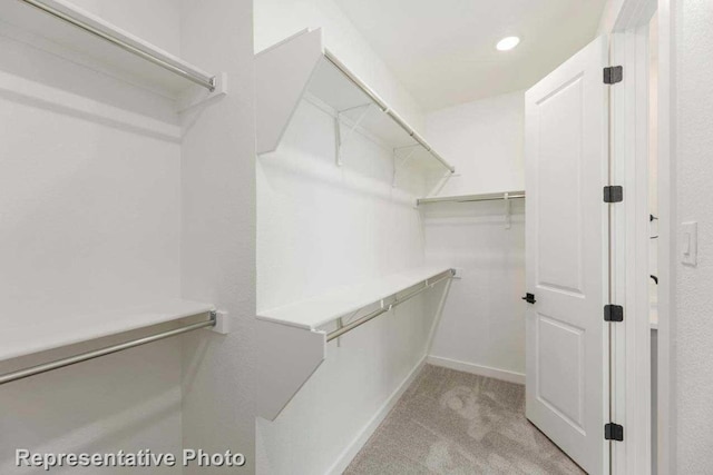 spacious closet with light colored carpet