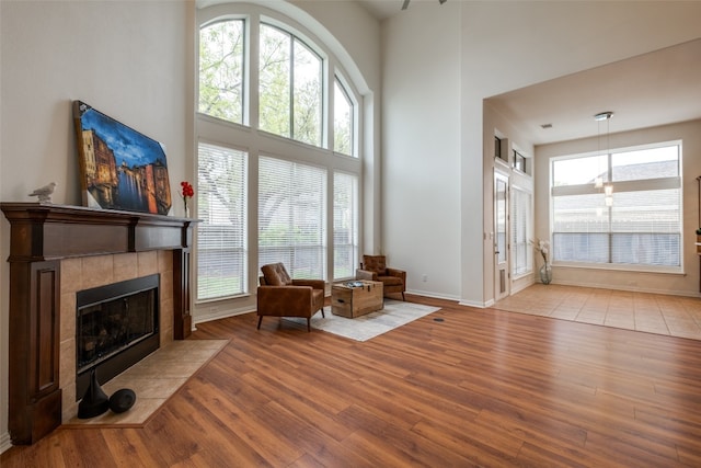 living room featuring a towering ceiling, tile flooring, and a tile fireplace