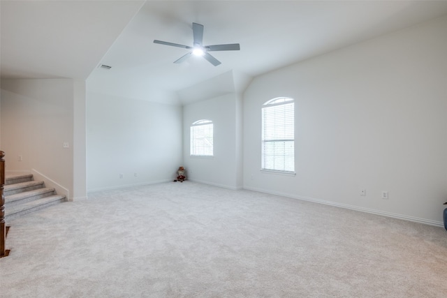 carpeted spare room with ceiling fan and vaulted ceiling