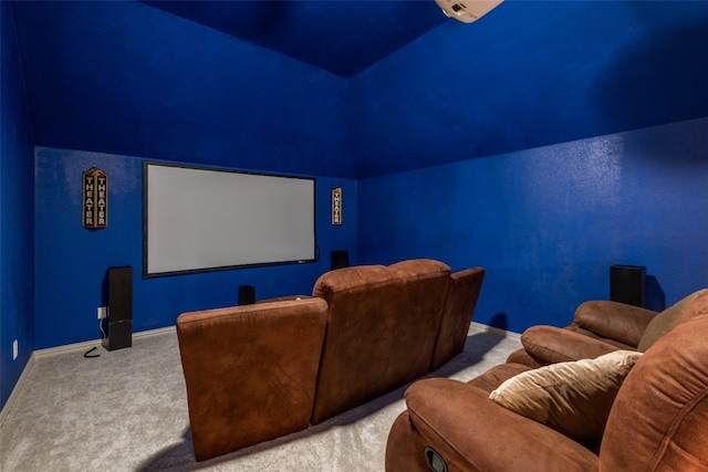 carpeted cinema room featuring vaulted ceiling