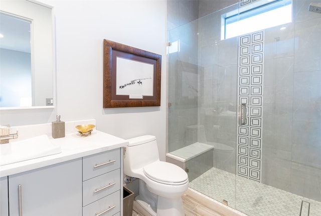 bathroom with hardwood / wood-style flooring, vanity, tiled shower, and toilet