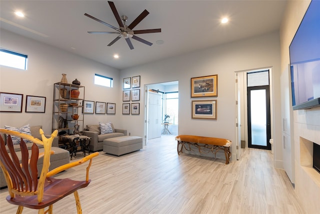 living room with ceiling fan, light hardwood / wood-style floors, and a wealth of natural light