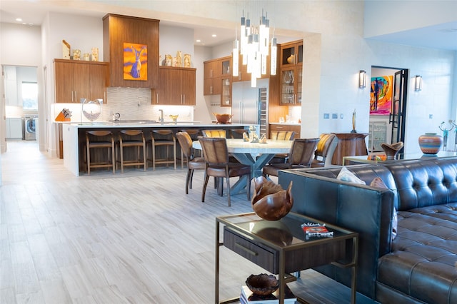 living room with washer / dryer and light hardwood / wood-style flooring