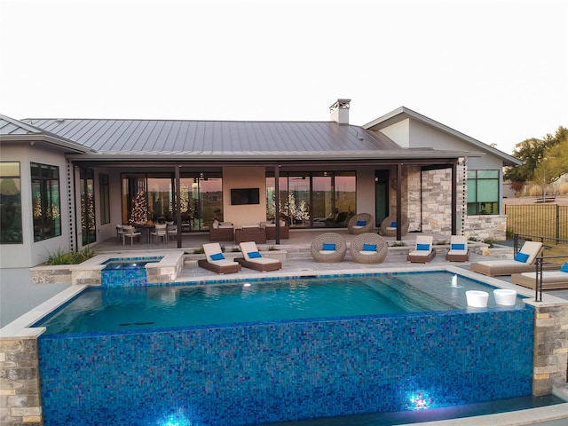 view of swimming pool featuring a patio area and an in ground hot tub