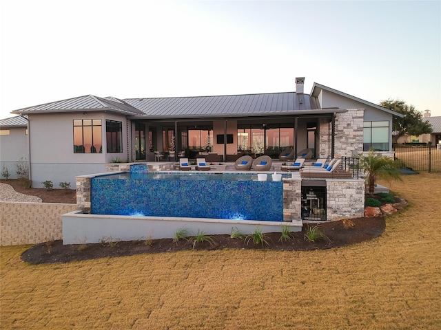 rear view of house with pool water feature and a yard