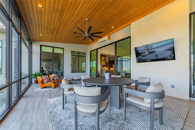 sunroom featuring wood ceiling, ceiling fan, and a wall mounted air conditioner