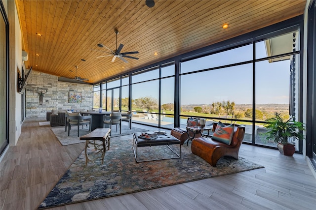 sunroom featuring ceiling fan, wooden ceiling, and a healthy amount of sunlight