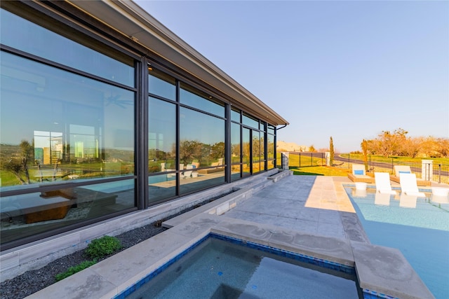 view of swimming pool featuring a jacuzzi and a patio area