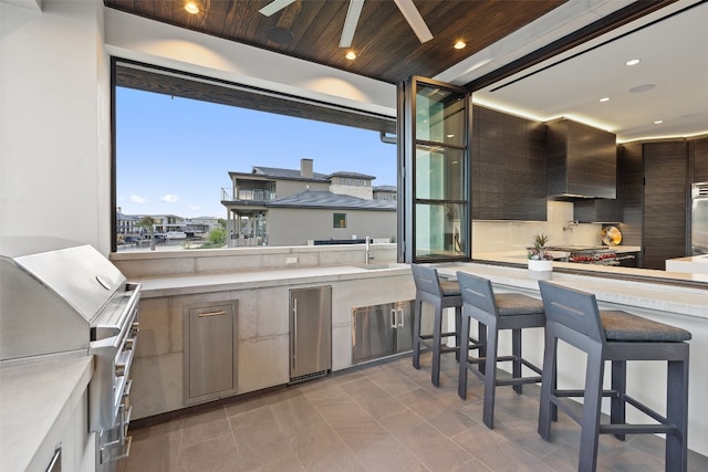 view of terrace featuring a wet bar, area for grilling, and ceiling fan