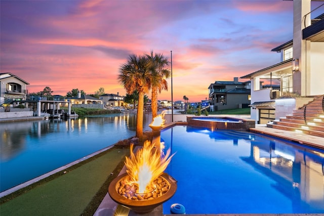 pool at dusk featuring an in ground hot tub and a fire pit