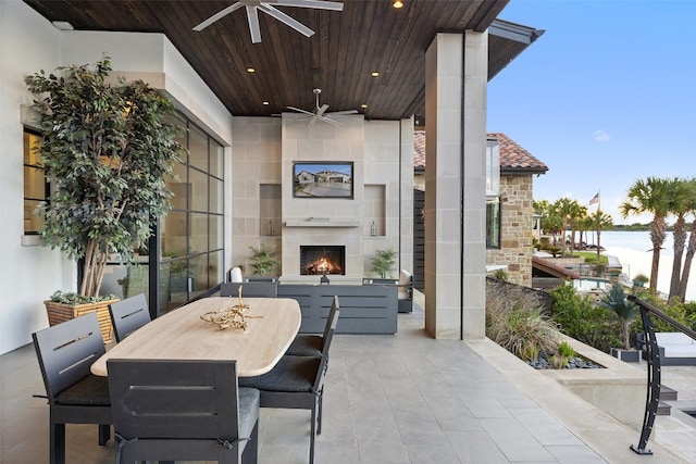 balcony with ceiling fan and exterior fireplace