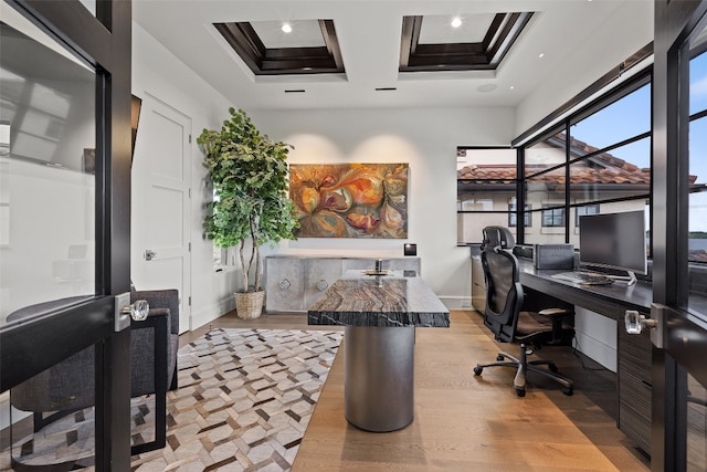 office area featuring light hardwood / wood-style floors, coffered ceiling, and built in desk