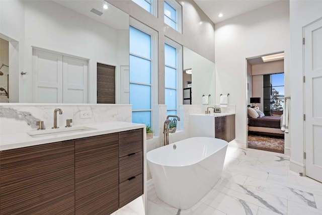 bathroom featuring tile walls, tile flooring, a high ceiling, and vanity