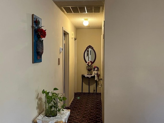 hall with carpet and a textured ceiling