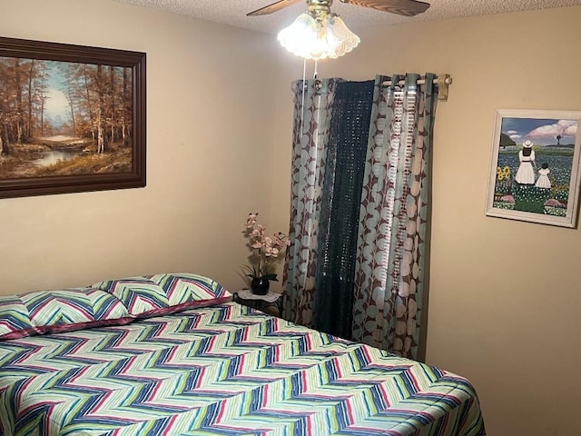 bedroom with ceiling fan and a textured ceiling