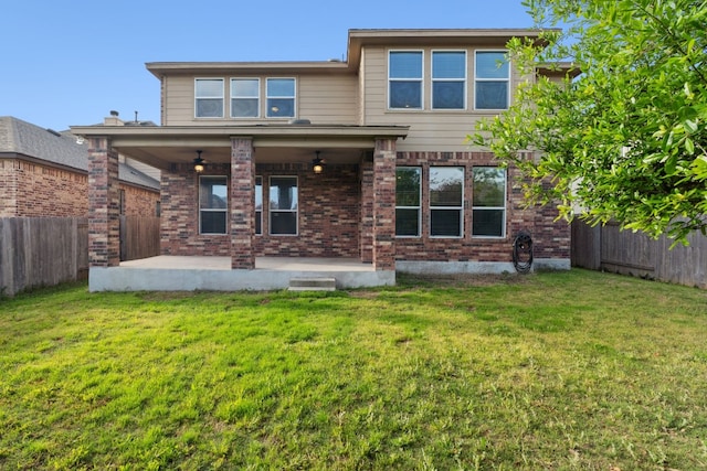 rear view of house featuring ceiling fan, a yard, and a patio