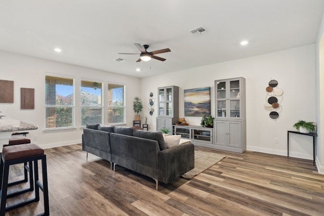 living room featuring ceiling fan and dark hardwood / wood-style flooring