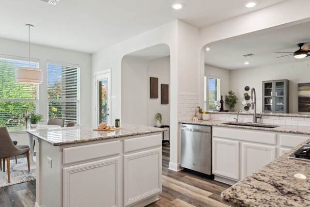 kitchen featuring stainless steel dishwasher, white cabinetry, and a wealth of natural light