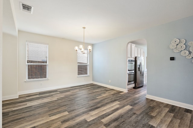 unfurnished dining area featuring a notable chandelier and dark hardwood / wood-style flooring