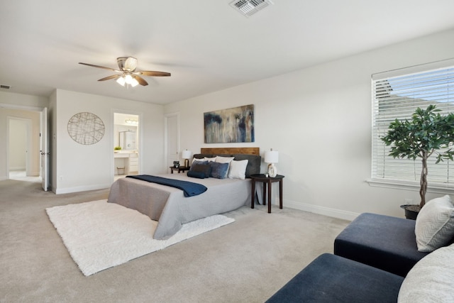 bedroom featuring ensuite bathroom, ceiling fan, and light colored carpet