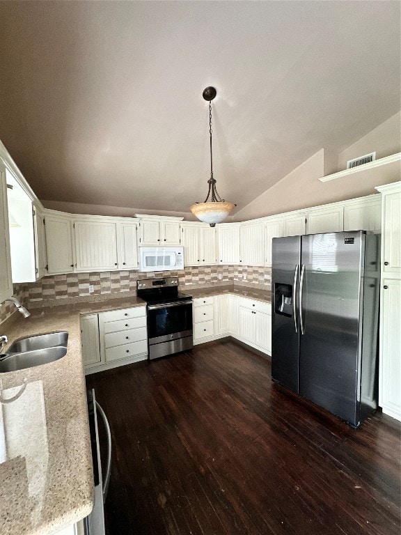 kitchen with sink, stainless steel appliances, white cabinets, and decorative light fixtures