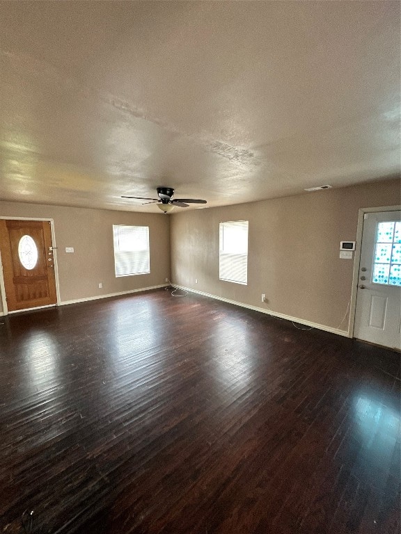 unfurnished living room featuring dark hardwood / wood-style flooring, a textured ceiling, and ceiling fan