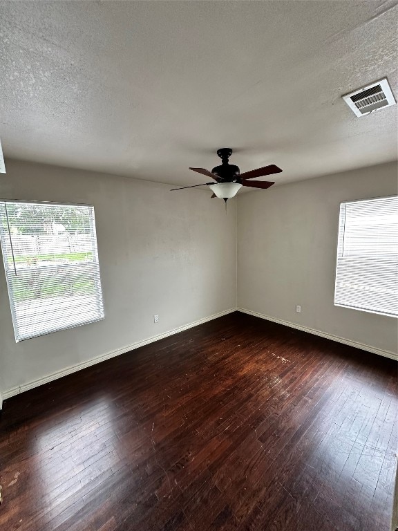 empty room featuring ceiling fan, a textured ceiling, and dark hardwood / wood-style flooring