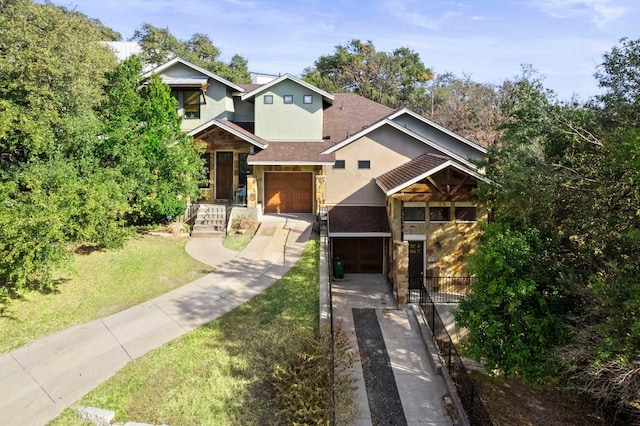 view of front of property featuring a garage, a shingled roof, driveway, stucco siding, and a front yard